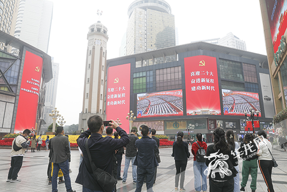 在重庆渝中区解放碑，市民正在收看中国共产党第二十次全国代表大会开幕会直播。华龙网-新重庆客户端记者 张质 摄