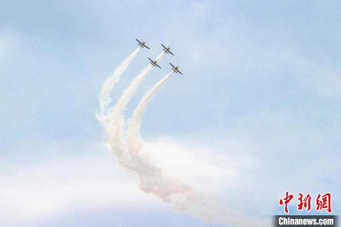 图为特技飞机编队在蓝天白云之下进行拉烟编队飞行表演。　刘力鑫 摄