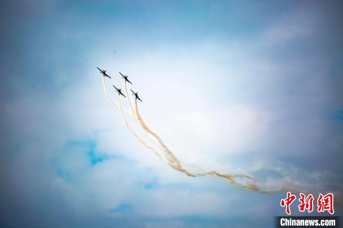 图为特技飞机编队在蓝天白云之下进行拉烟编队飞行表演。　马刚 摄