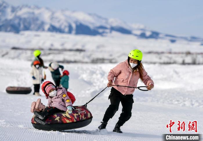 市民带着孩子滑雪圈。　刘新 摄