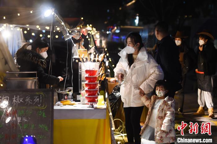 12月14日晚，重庆市民在南岸区南滨路的小熊集市上选购美食。　何蓬磊 摄