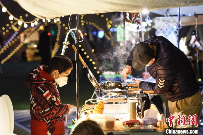 12月14日晚，一位小朋友在南岸区南滨路的小熊集市上选购美食。　何蓬磊 摄