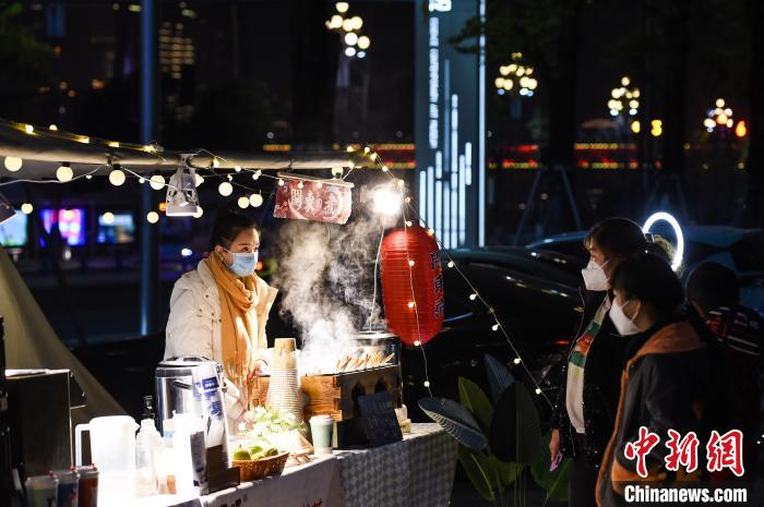 12月14日晚，重庆市民在南岸区南滨路的小熊集市上选购美食。　何蓬磊 摄
