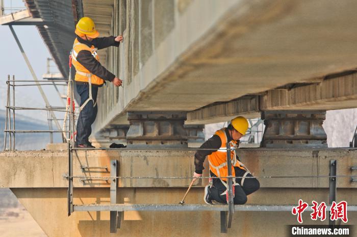 图为铁路职工在铁路桥梁上进行检测维护作业。　张中海 摄