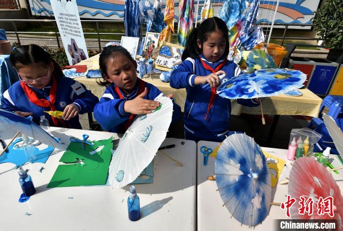图为小学生在活动上展示扎染技艺在福州油纸伞制作上的运用。　张斌 摄