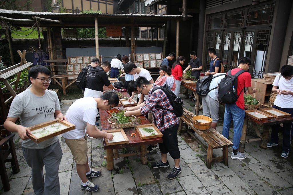 7月6日，在贵州省丹寨县万达小镇一家非遗体验馆，大学生在体验花草纸制作。（3）.JPG