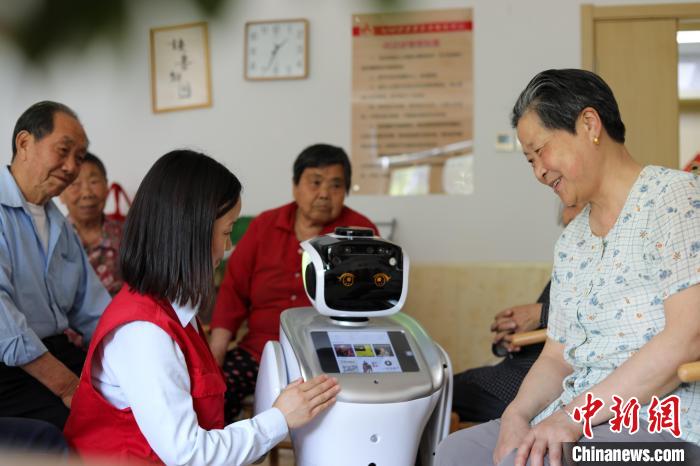 在上派镇爱和家养老服务中心，志愿者通过智能机器人播放有声书，帮助老人“阅读”。　陈家乐 摄