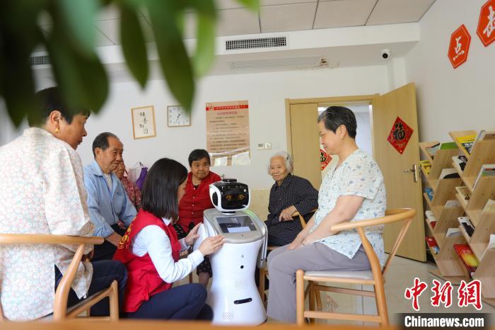在上派镇爱和家养老服务中心，志愿者通过智能机器人播放有声书，帮助老人“阅读”。　陈家乐 摄