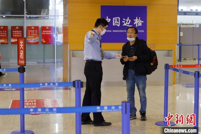 在浦东机场T2航站楼内，边检民警引导市民在快捷通道办理出境手续。　殷立勤 摄