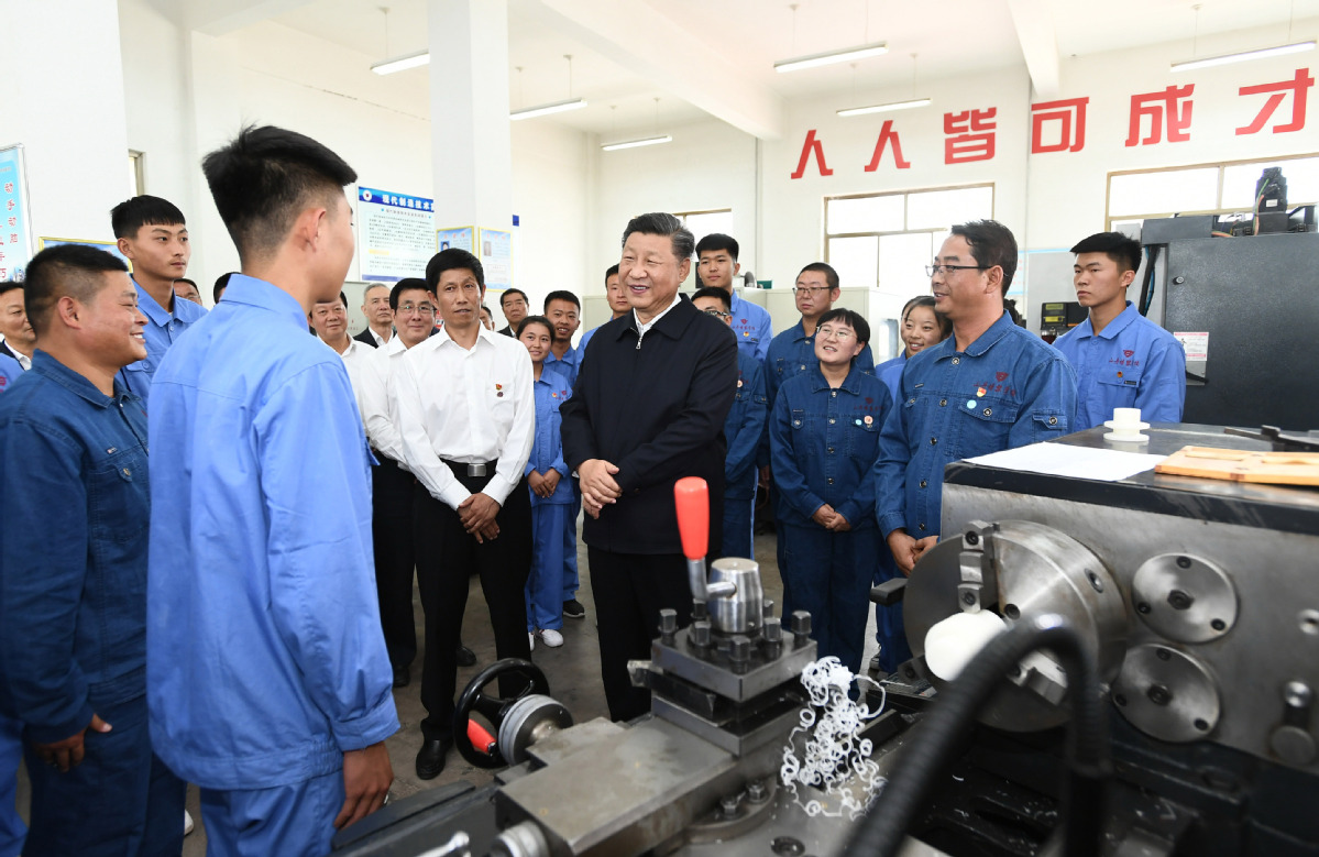 2019年8月20日，习近平在甘肃省张掖市山丹培黎学校现代制造技术实训室，观看职业技能实训，同师生亲切交流。