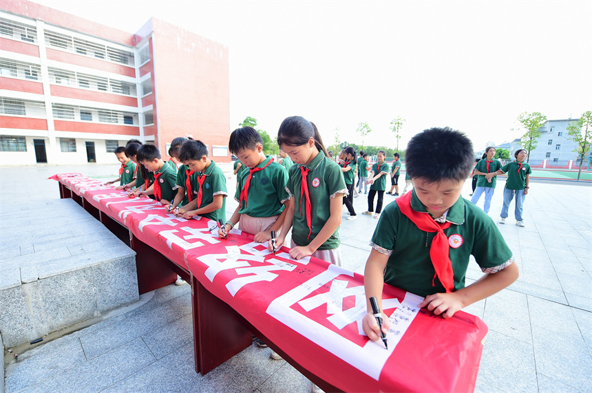 会昌县第八小学学生在“网络安全为人民、网络安全靠人民”宣传条幅上签名。吕春华摄
