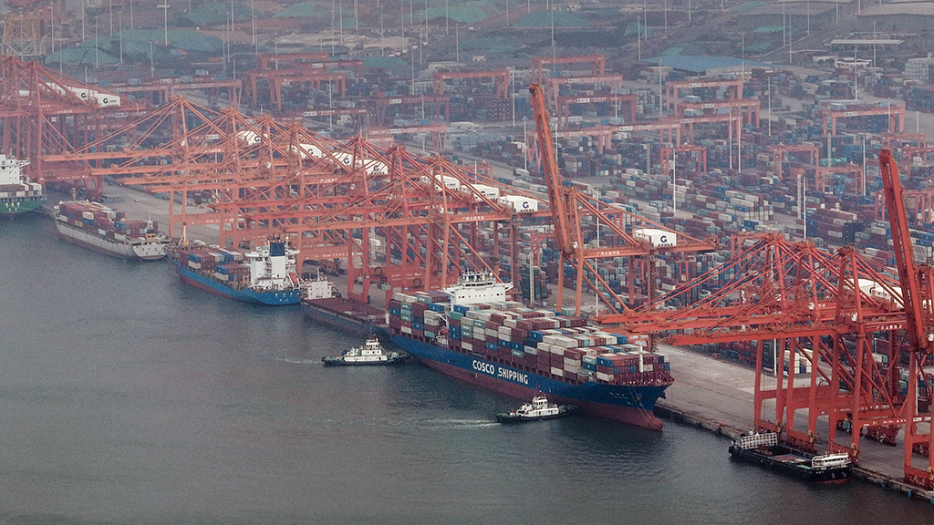 10月26日，在钦州港集装箱装卸码头，海事船正在协助海轮离岸（无人机照片）。